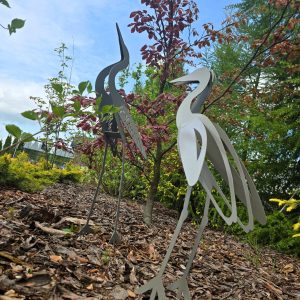 dwie wycinane laserowo czaple stojące w ogrodzie