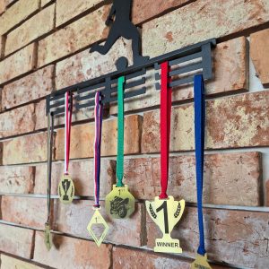 różne wycinane laserowo medale wiszące na wieszaku