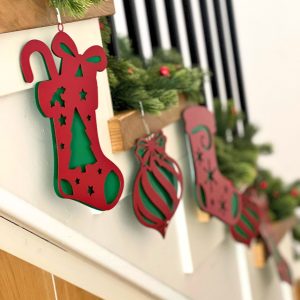 Aranżacja bożonarodzeniowa składająca się z wielu różnych bombek w kolorze czerwono zielonym. Zdobi schody.