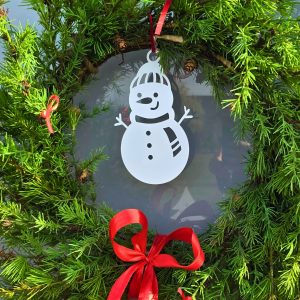 Zdjęcie przedstawia bombkę bałwanka wykorzystanego jako część dekoracji świątecznego wianka.